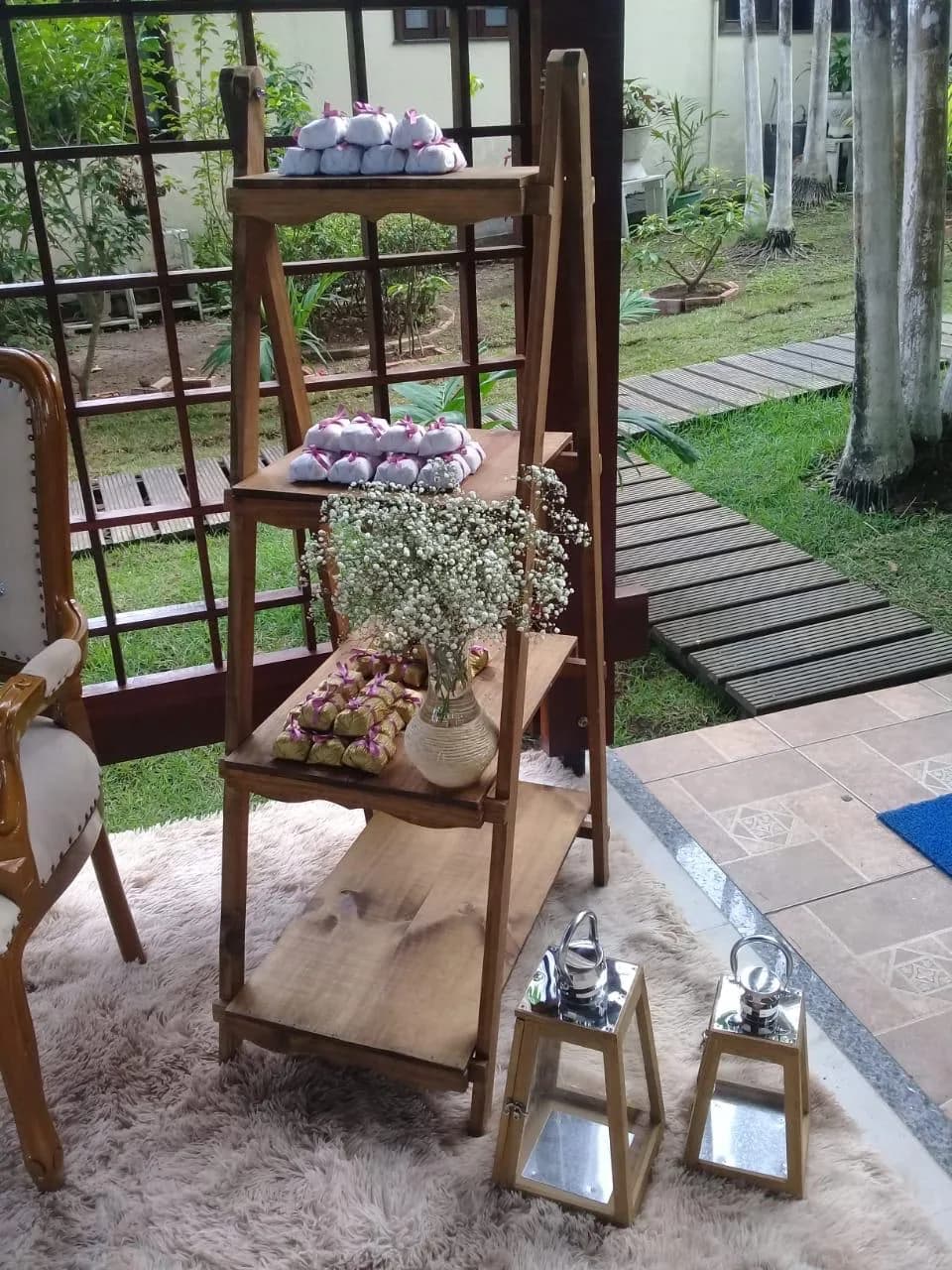 Estante de doces decorada no jardim da pousada, com a piscina ao fundo