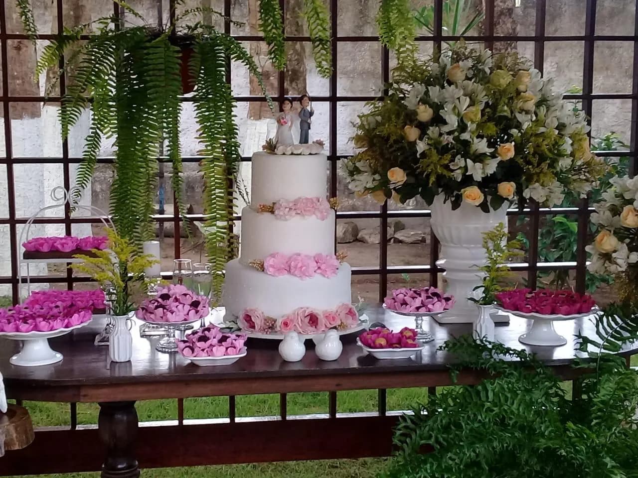 Bolo e mesa de doces na área externa decorada da pousada